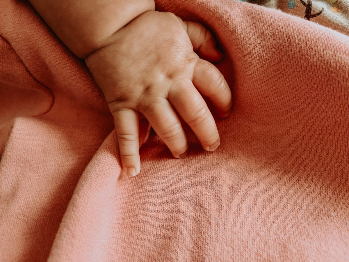Baby hand on pink blanket