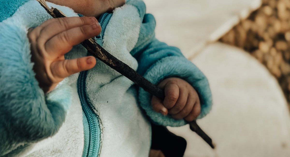 Infant playing with a stick