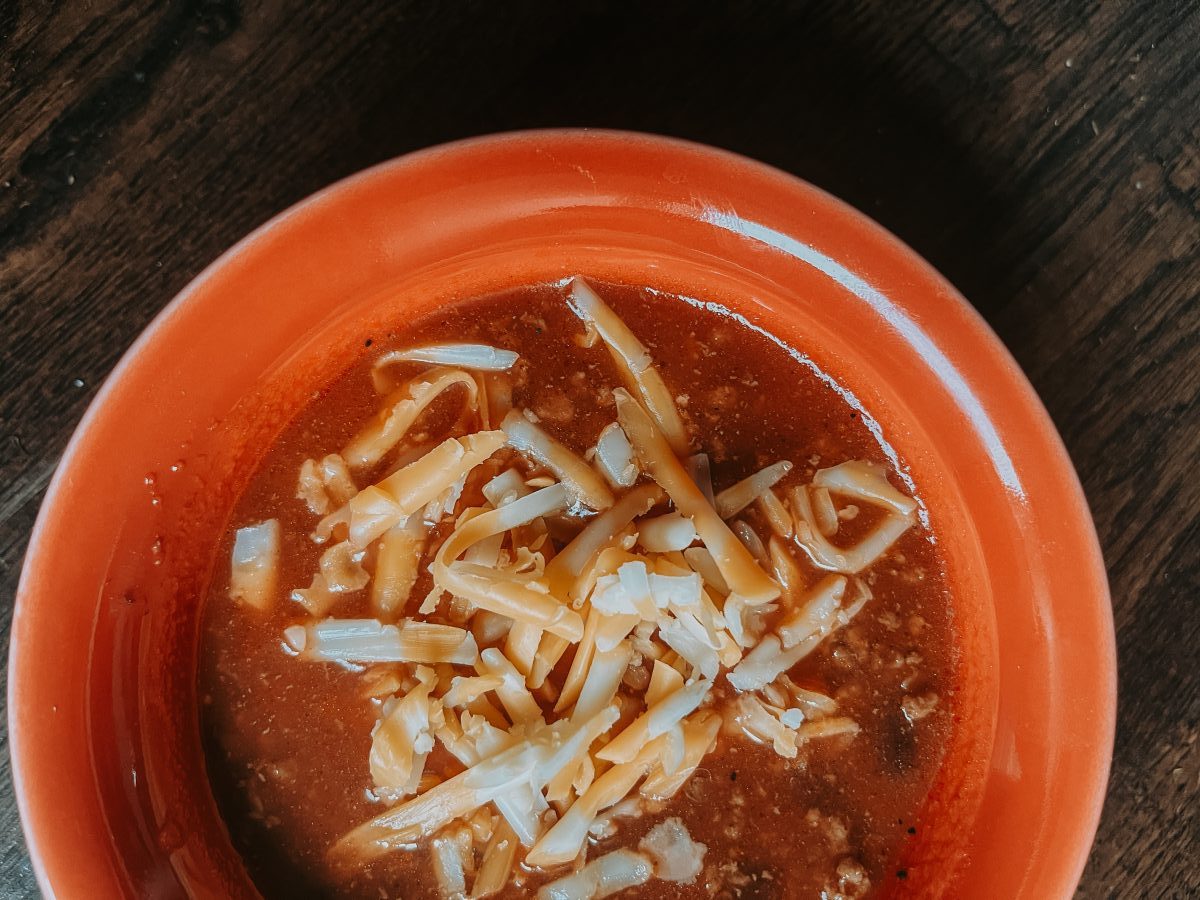 Bison Chili with cheese on top in red bowl